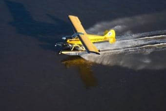 Yellow seaplane taking off from the water.