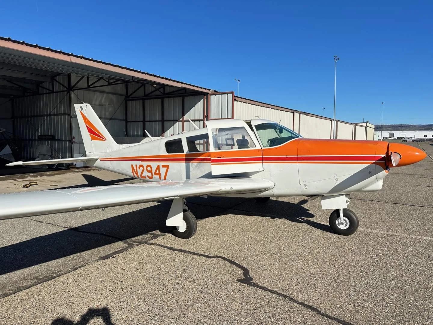 Side view of the N2947 aircraft parked outside a hangar.