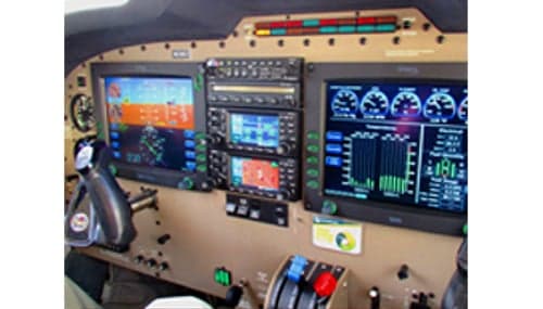 A modern aircraft cockpit featuring multiple digital displays and a control yoke.