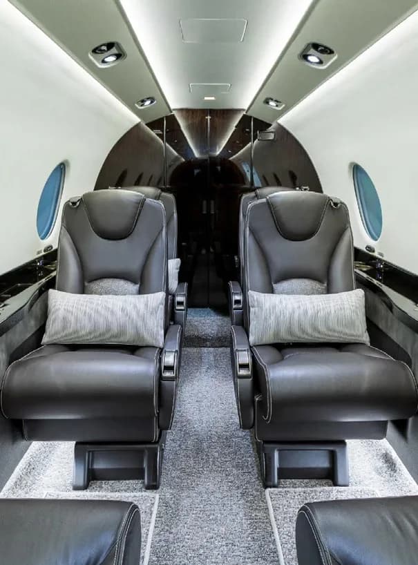 The interior of a King Air 350 aircraft with leather seats and round windows.