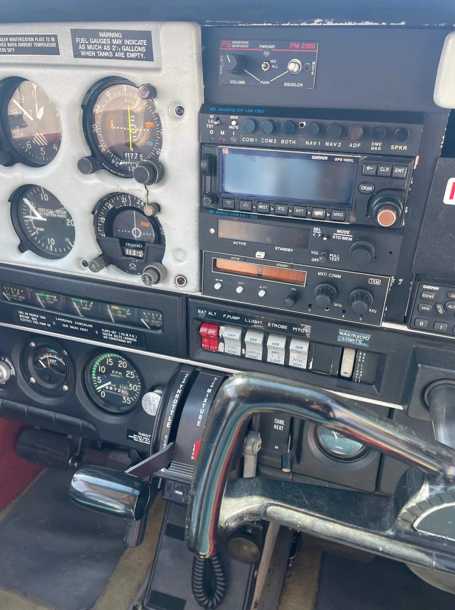 Detailed view of an aircraft's instrument panel, radio stack, and control levers.