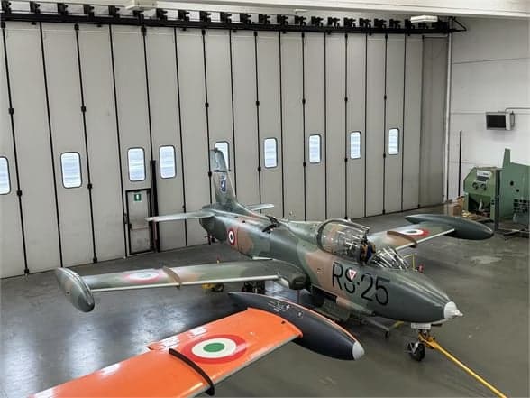 Camouflaged aircraft I-MBCK parked on the tarmac.