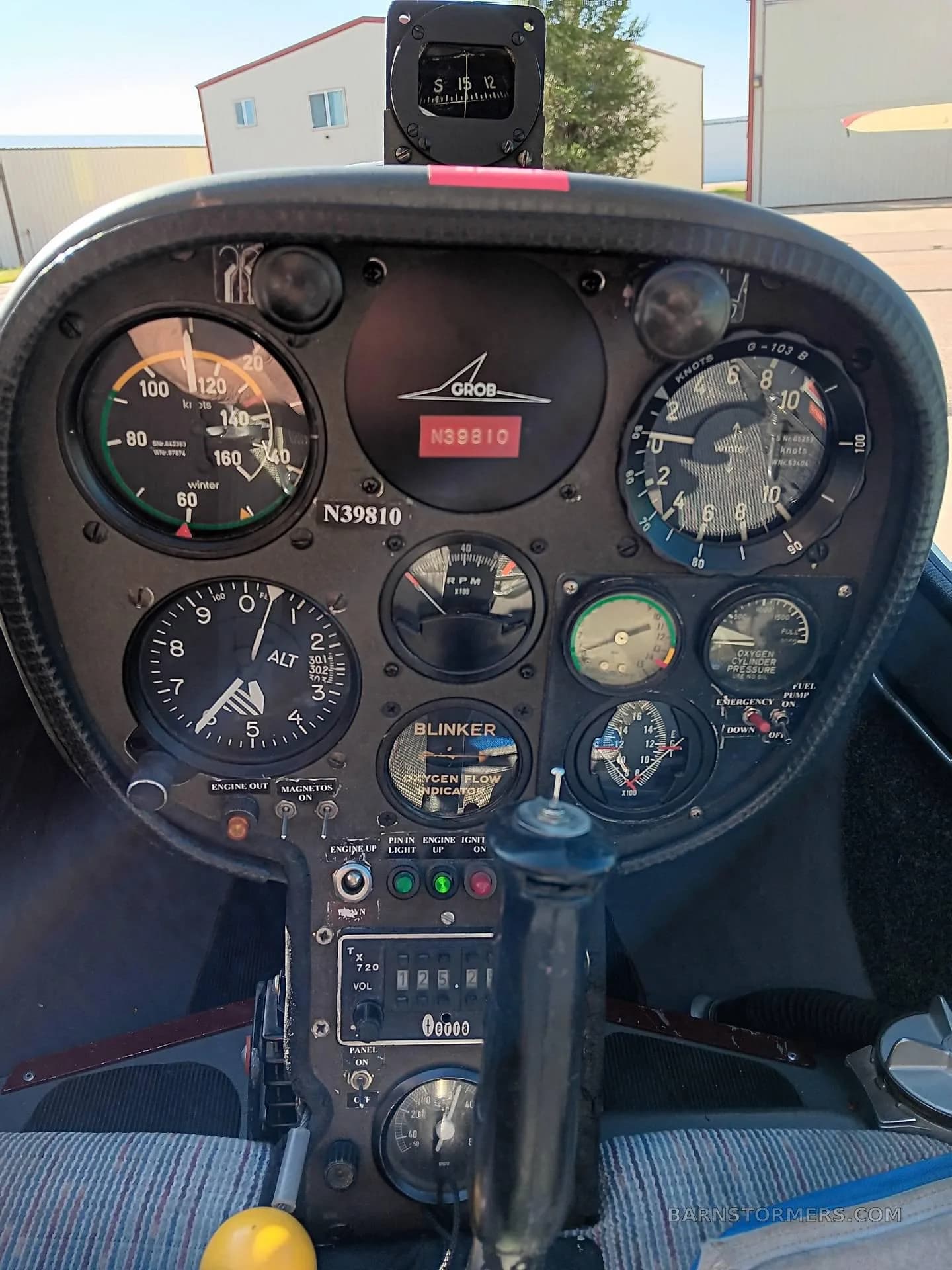 The instrument panel of a Grob G 103 glider, featuring various gauges, switches, and a control stick.