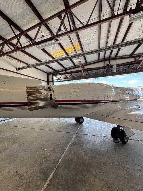 Engine and wing of a Learjet 35A in a hangar.