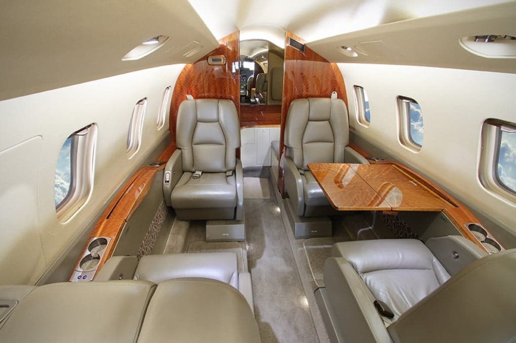 The interior of the Piaggio Avanti EVO with leather seats and wood trim.