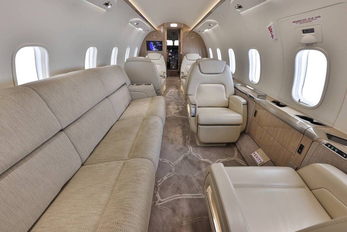View of the aircraft's interior with beige seats and carpet.