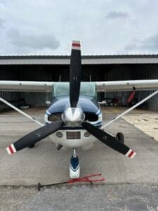 Front view of a Cessna aircraft showing the propeller and nose.