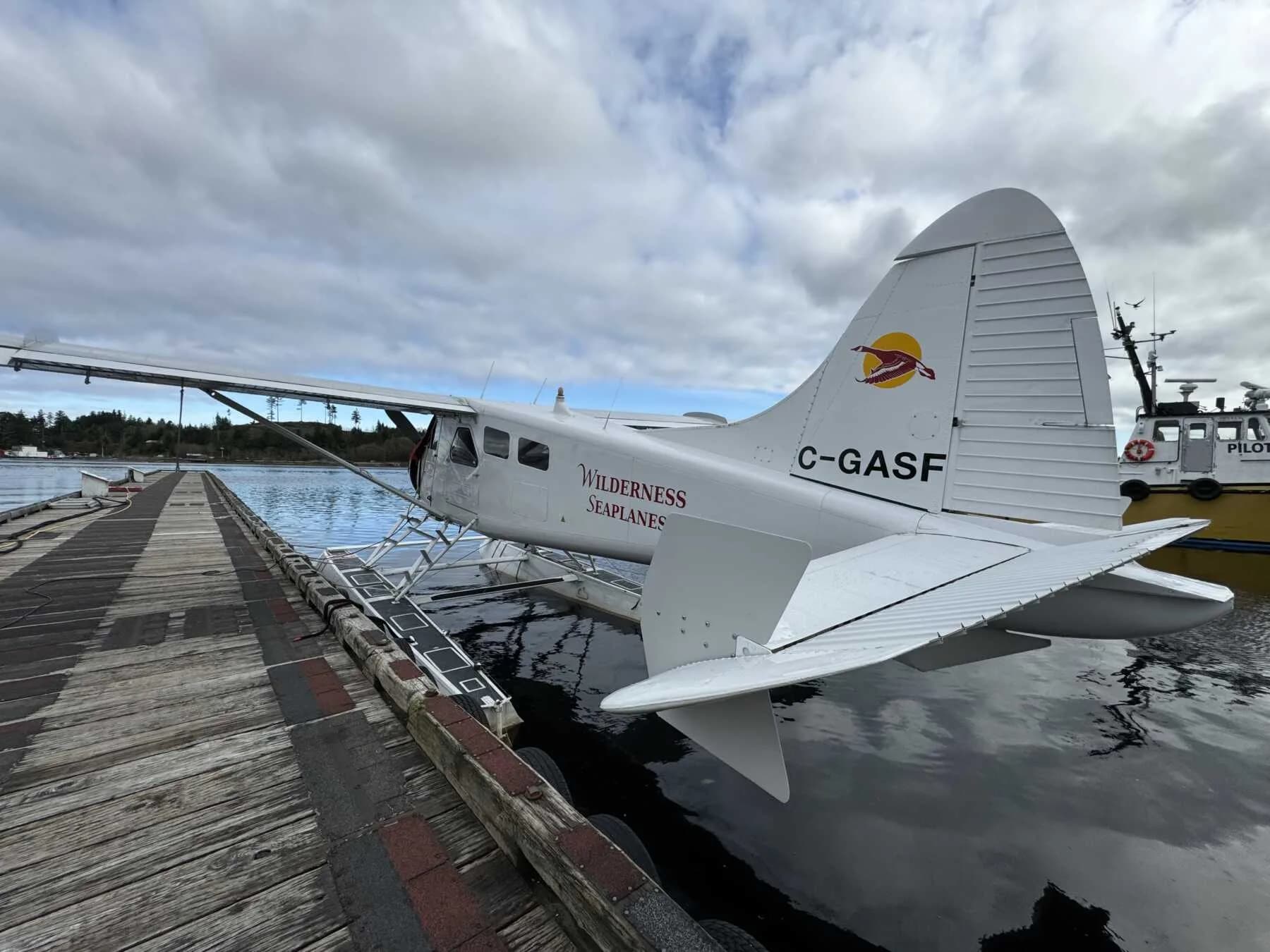 Rear view of a de Havilland Beaver floatplane on a dock, showing the tail number C-GASF.