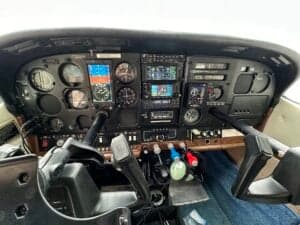 The cockpit of a Cessna aircraft showing the instrument panel and control yokes.
