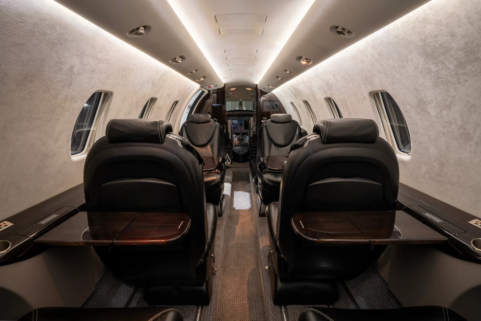 View of the Cessna Citation XLS+ cabin looking forward with tables extended.