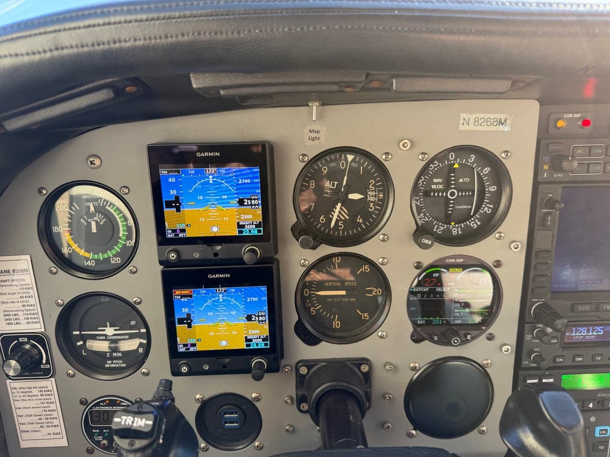 A detailed view of the N8268M aircraft's instrument panel, highlighting the Garmin displays and other instruments.