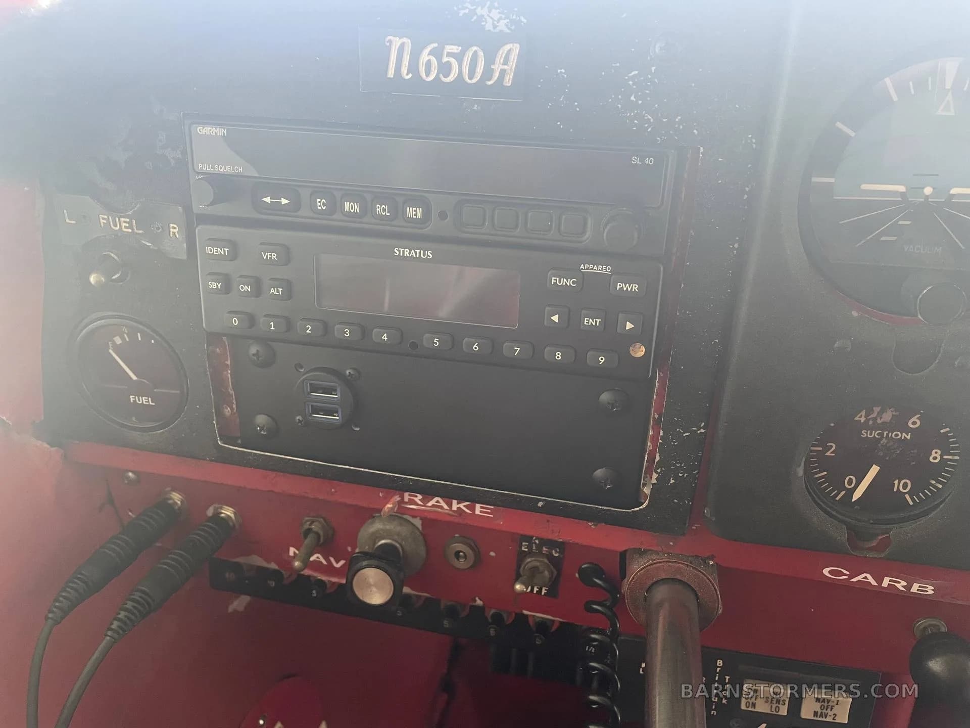 A close-up view of the aircraft's instrument panel, showing a Garmin radio and other avionics.