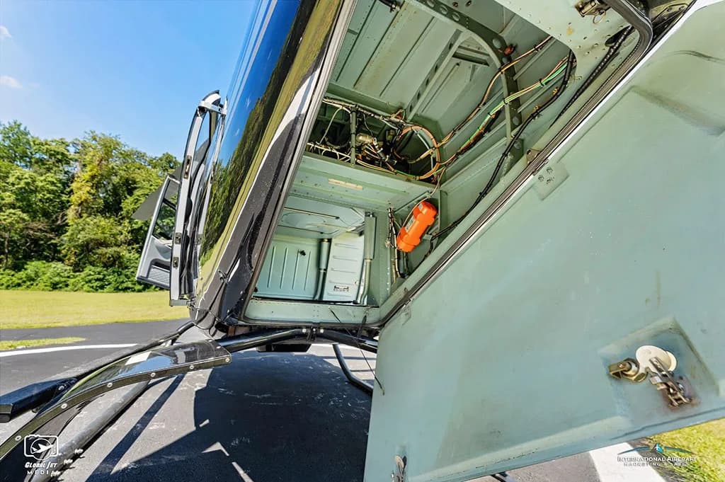 An open compartment on the side of the helicopter revealing internal wiring and components.