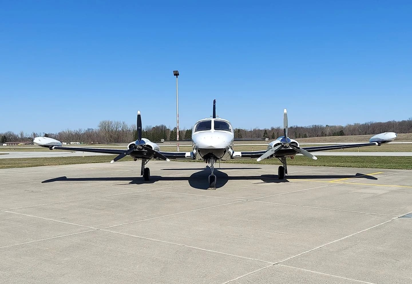 Front view of a Cessna 414 aircraft with registration N977SM parked on the tarmac.