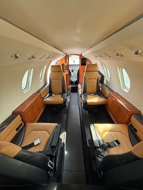 Interior of a Cessna Citation CJ3+ with leather seats and wood trim.