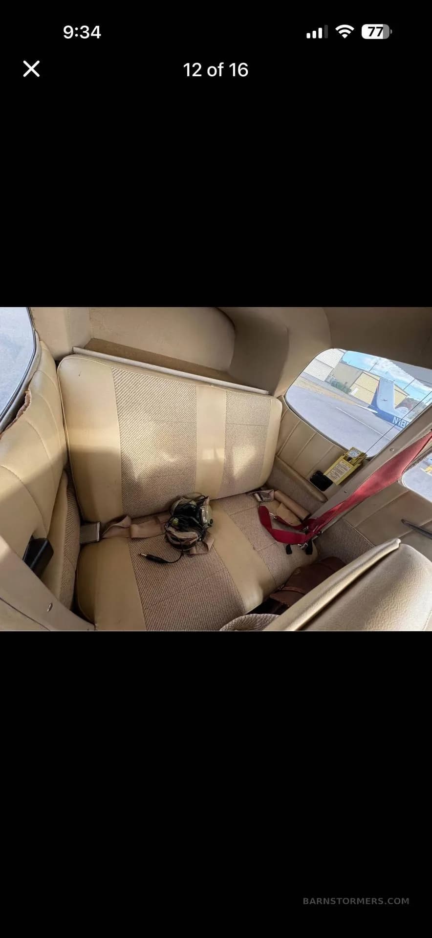 The beige rear seats of a light aircraft cabin, with a headset resting on one seat.