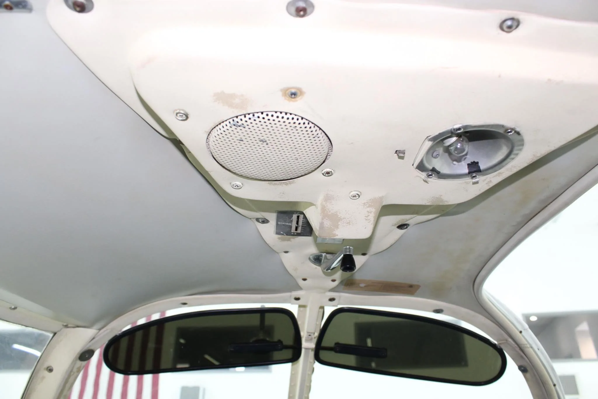 Overhead panel in an aircraft cockpit with a speaker and light.