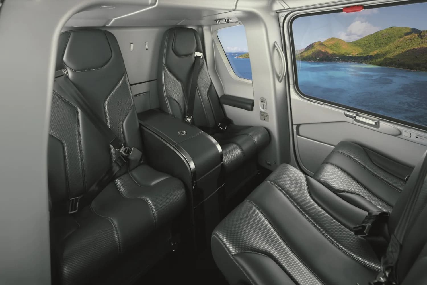 The luxurious black leather interior cabin of a helicopter with a tropical island view from the window.