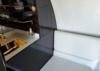 Interior view of the aircraft with a sink and seating area.