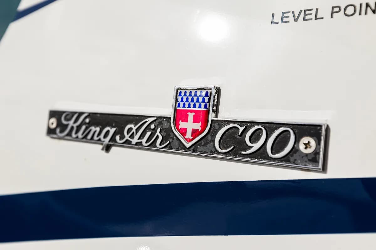 Close-up of the 'King Air C90' model badge on the side of the aircraft.