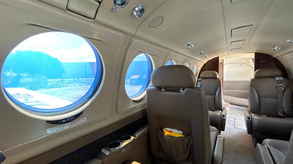 Interior of a King Air 250 with leather seats and round windows.