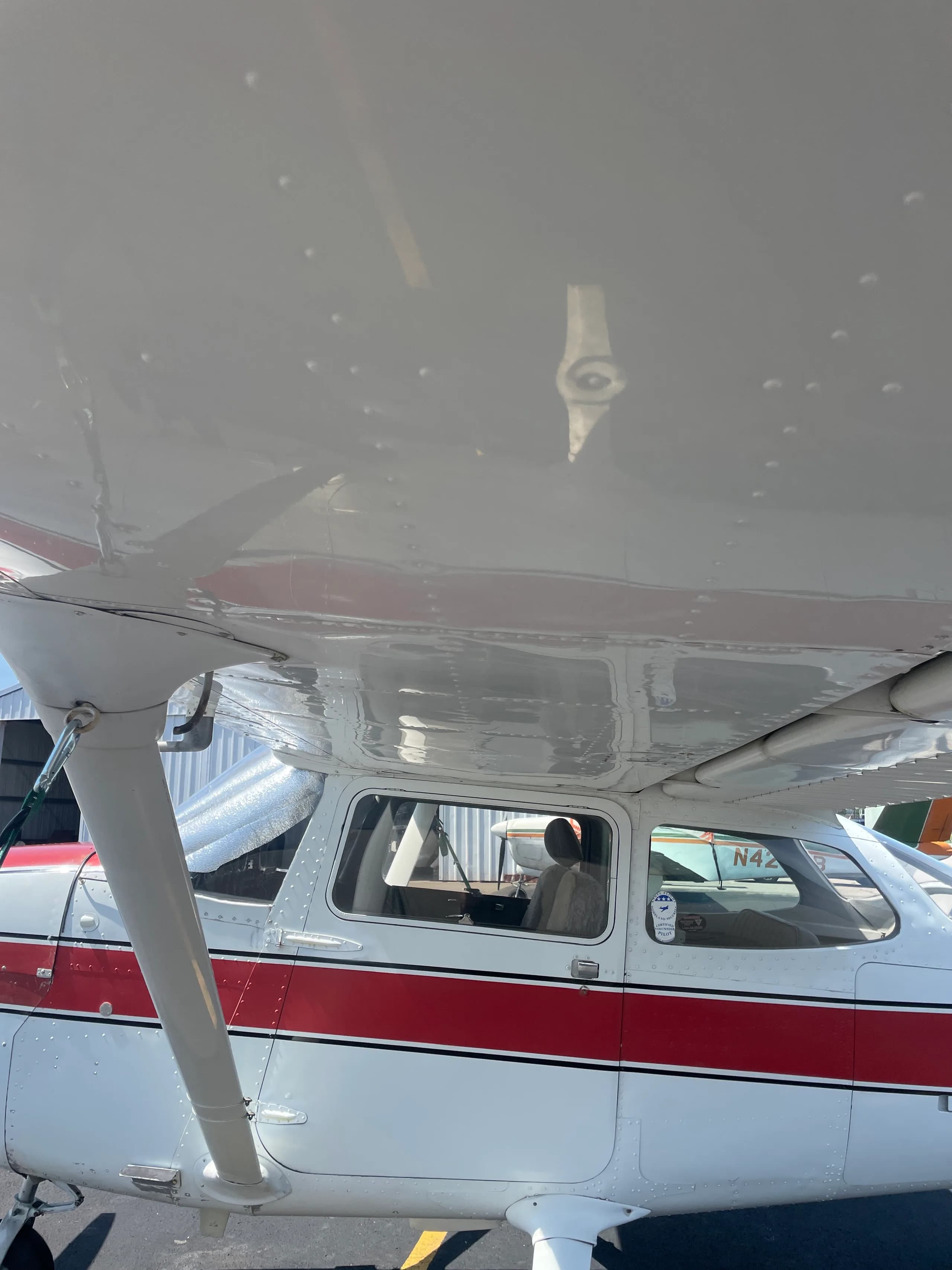 A close-up view of the cockpit area of the white and red Cessna 172, registration N733EN, showing the side windows.