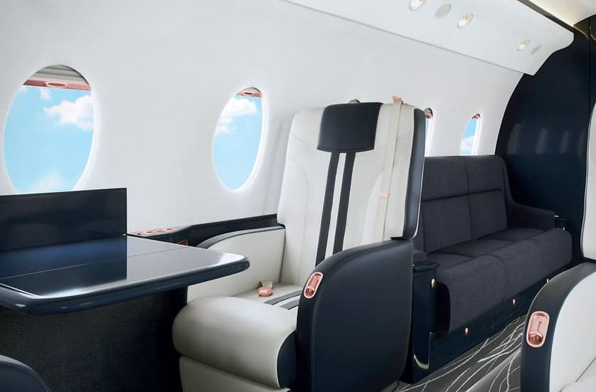 A luxurious aircraft interior features a sofa and leather seats.