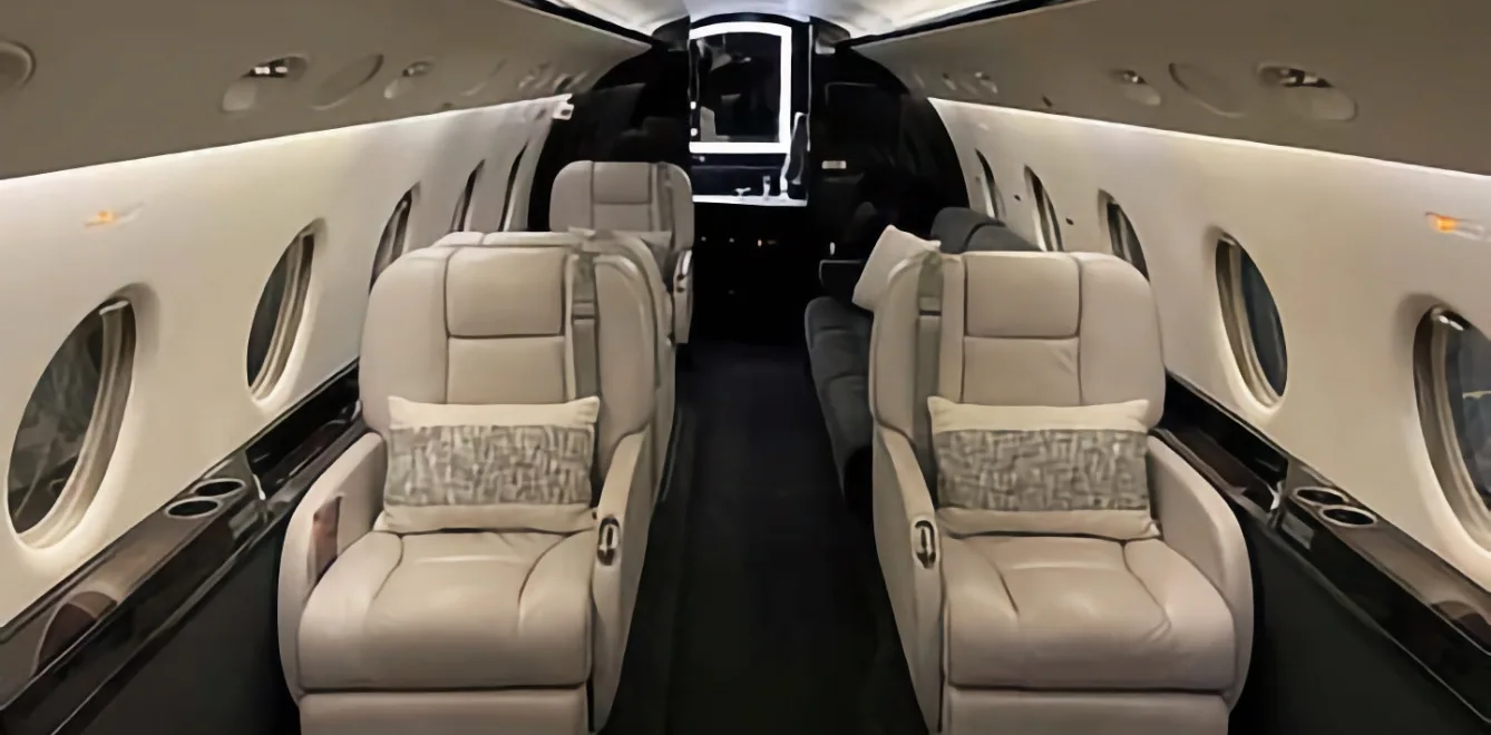 The interior of the aircraft features leather seats and dark wood accents.