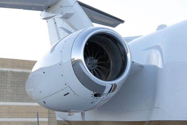 A close-up view of the polished chrome engine nacelle and fan blades of a business jet.