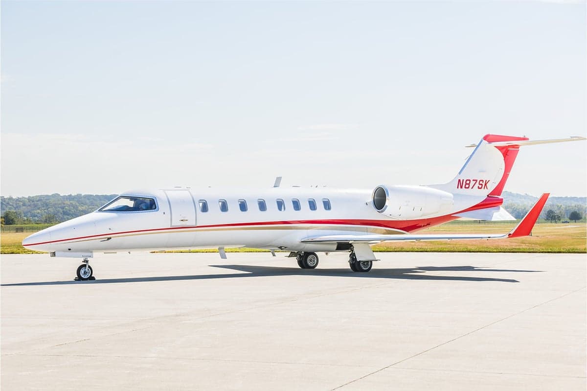 A Learjet 45XR with a white and red paint scheme on the tarmac.