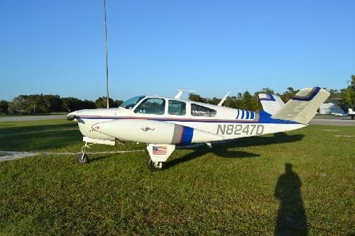A Beechcraft Bonanza with tail number N8247D is parked on the grass.