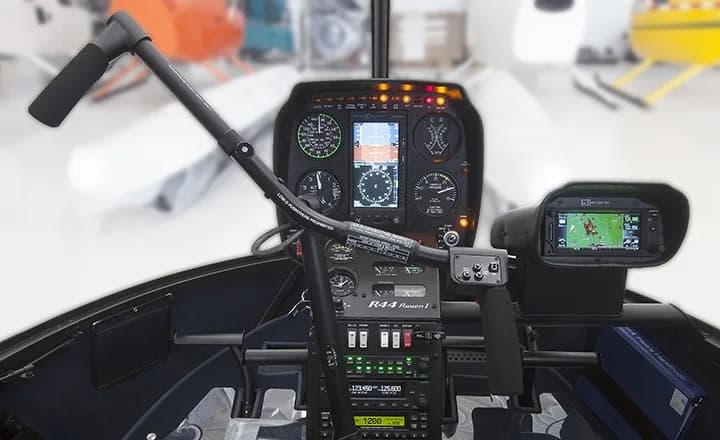 Cockpit view of a Robinson R44 helicopter with modern avionics.