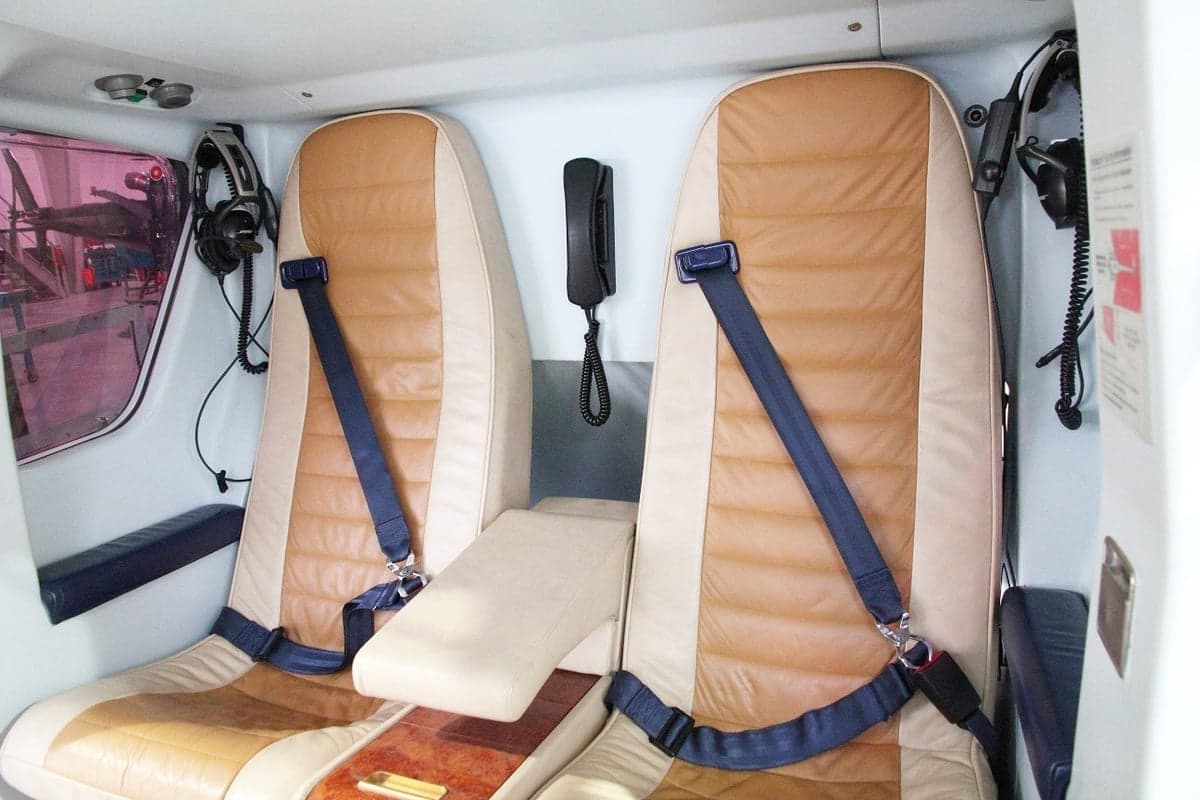 A view of the interior seats of a helicopter with headsets.