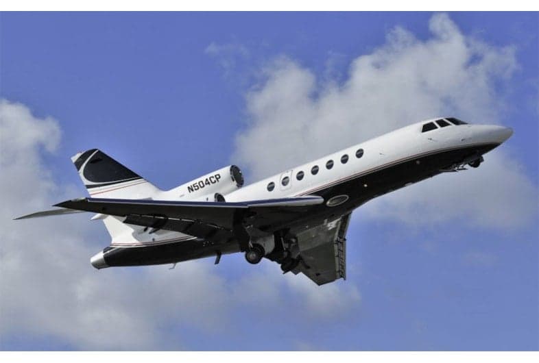N504CP taking off against a blue sky with clouds.