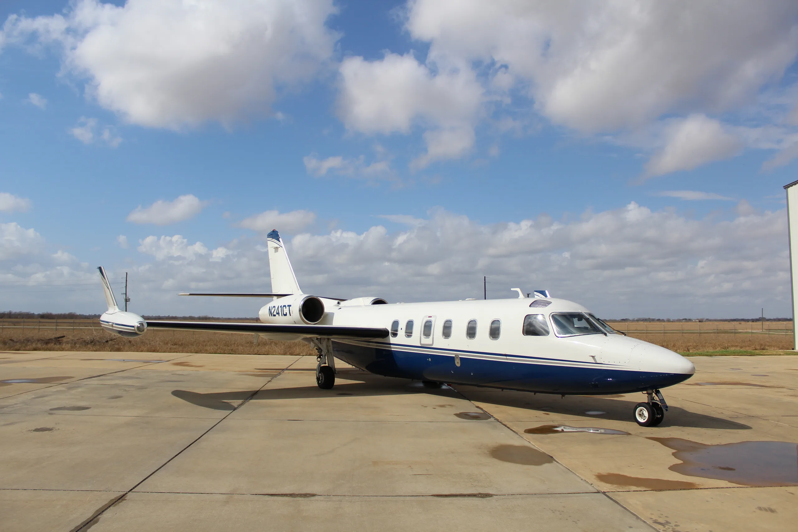 A Westwind Astra SPX aircraft with registration N241CT parked on the tarmac under a cloudy sky.