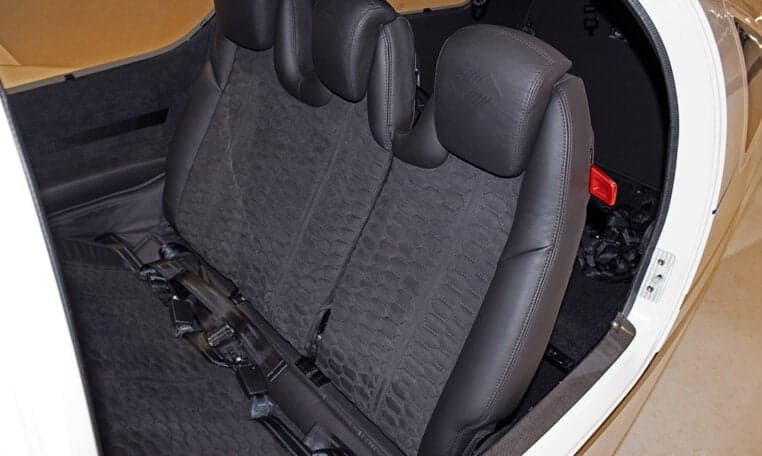 The rear seats of a Diamond DA62 aircraft with black leather upholstery.
