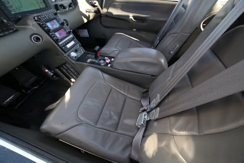 Interior view of a Cirrus SR22 aircraft, focusing on the front seats and cockpit controls.