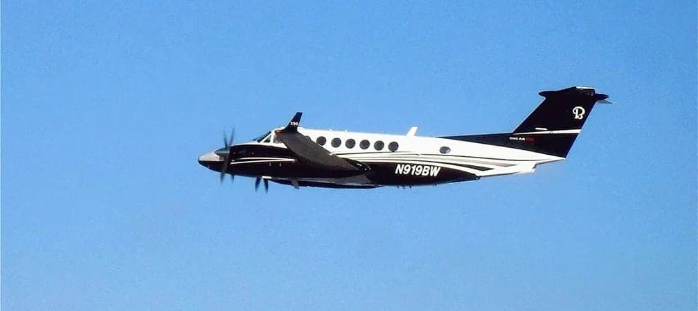 A King Air 350 in flight against a blue sky.