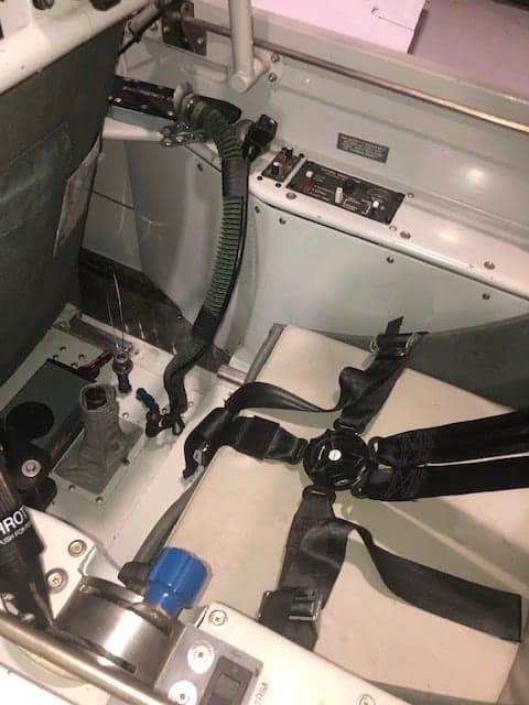 View of the aircraft's seat and harness inside the cockpit.
