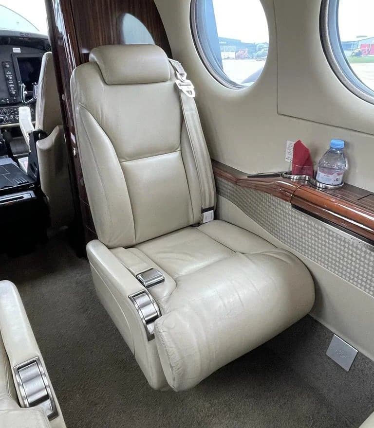 Leather seat in the aircraft cabin with a side table.