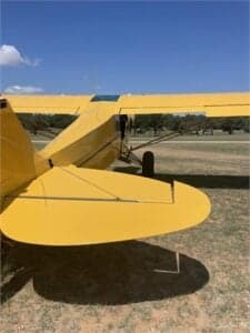 Close up of the tail of a yellow Cubcrafters aircraft.