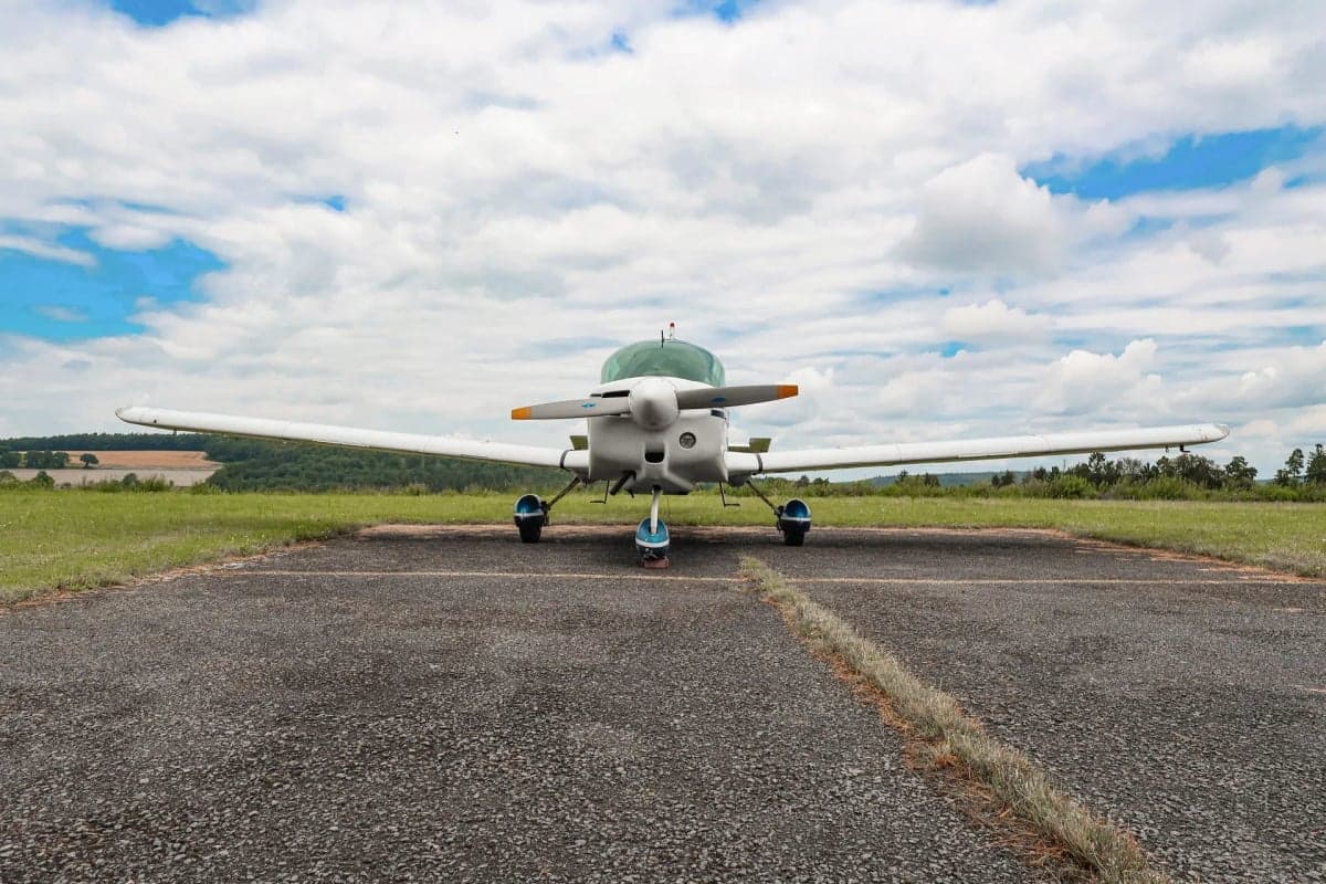 Front view of a white and blue aircraft with the registration D-EEHT parked on a runway.