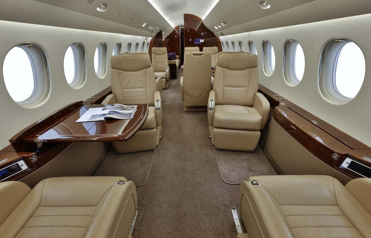 The aircraft's interior features tan leather seats and wood accents.