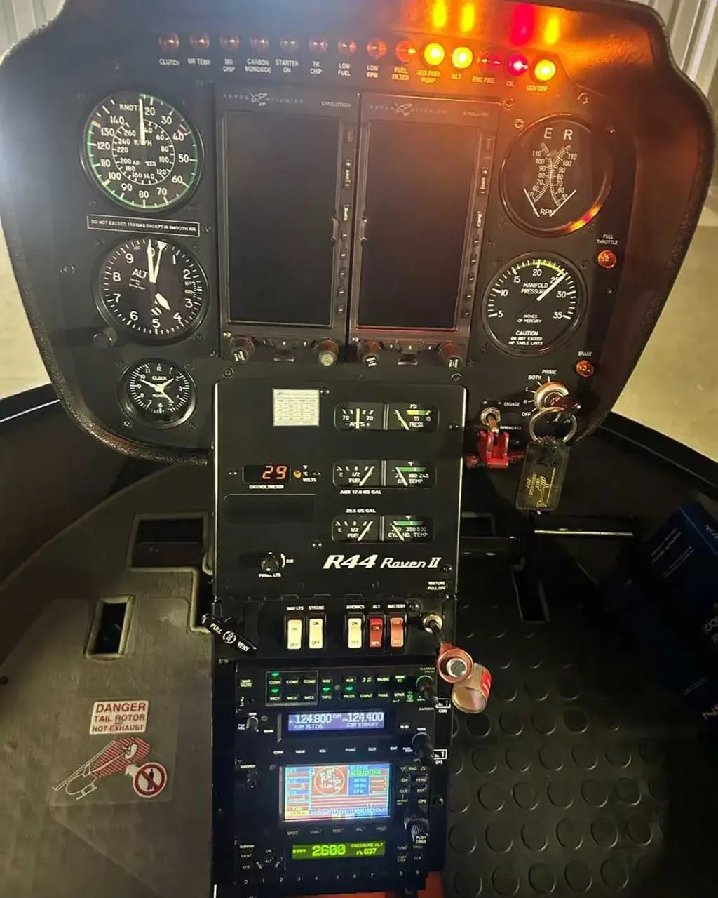 A close-up view of the instrument panel and avionics of a Robinson R44 Raven II helicopter.