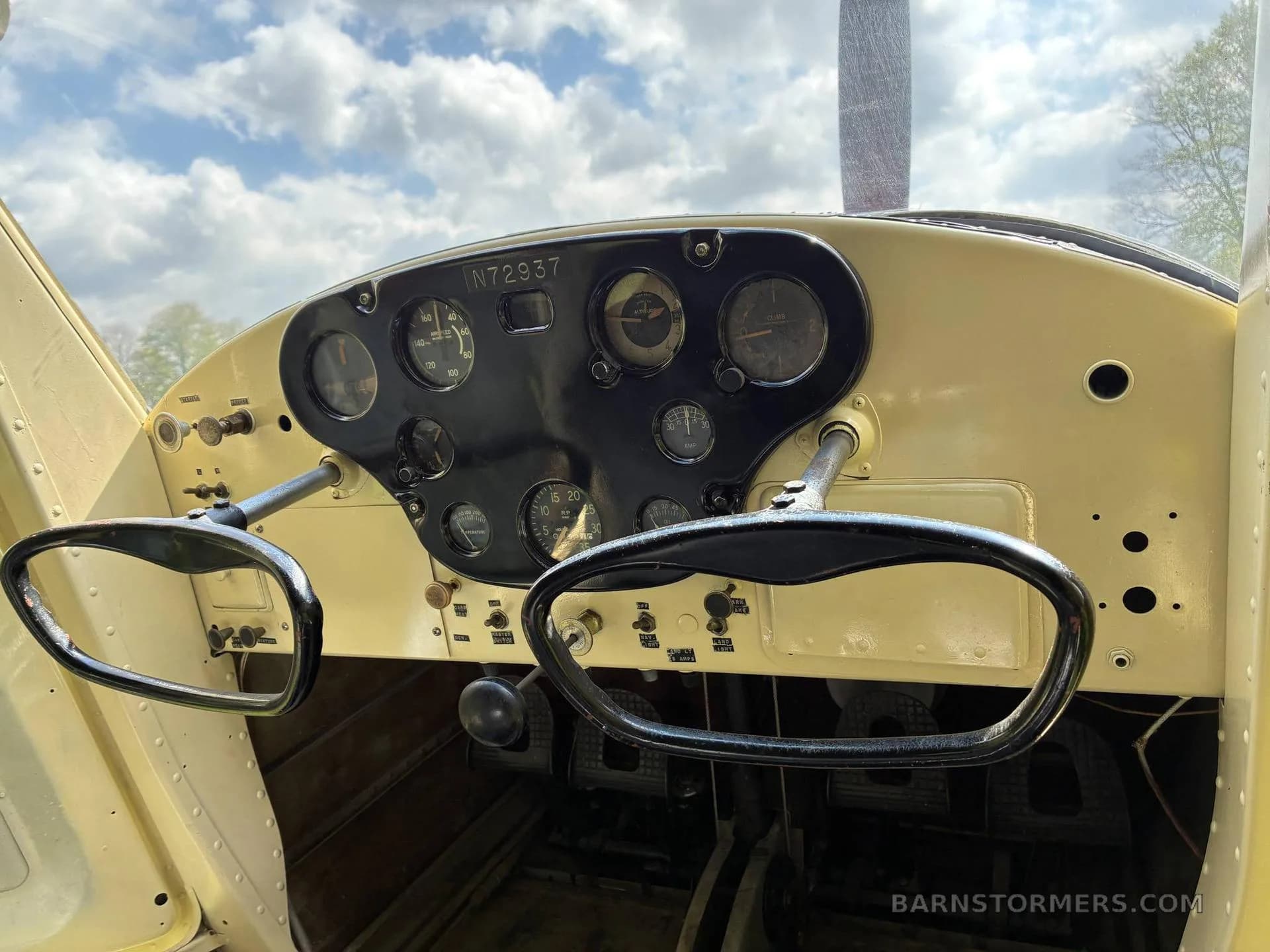 The vintage cockpit of the aircraft, featuring a black instrument panel with analog gauges and two control yokes.