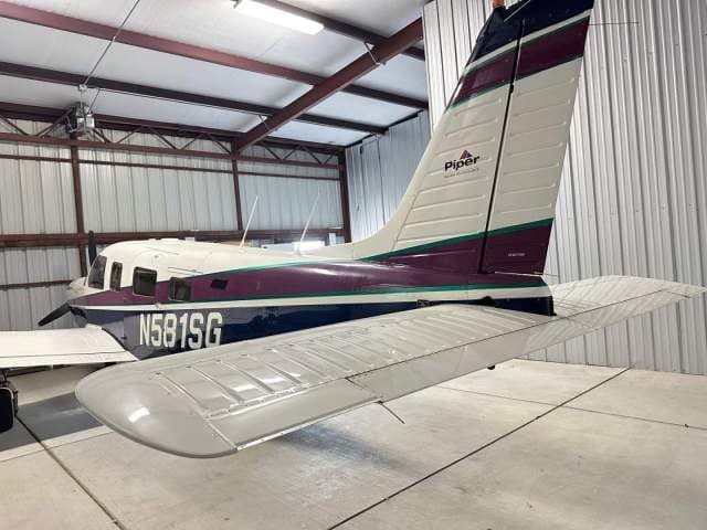 Rear-side view of the Piper Saratoga II TC (N581SG) aircraft parked inside a hangar.