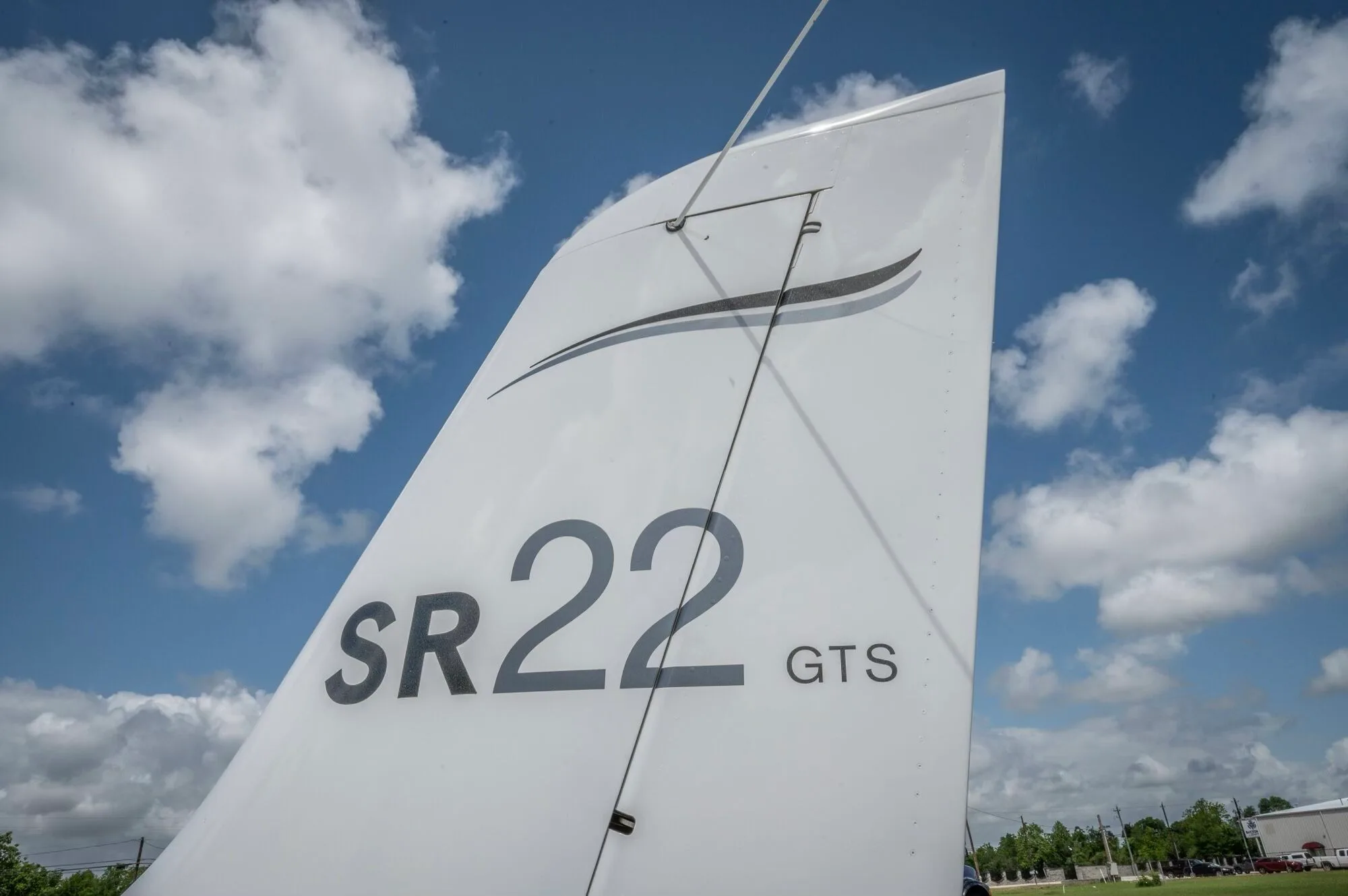 A close-up of the tail of the white Cirrus SR22 GTS aircraft, showing the SR22 GTS designation.