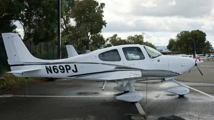 Side view of a Cirrus aircraft with registration N69PJ on the ground.