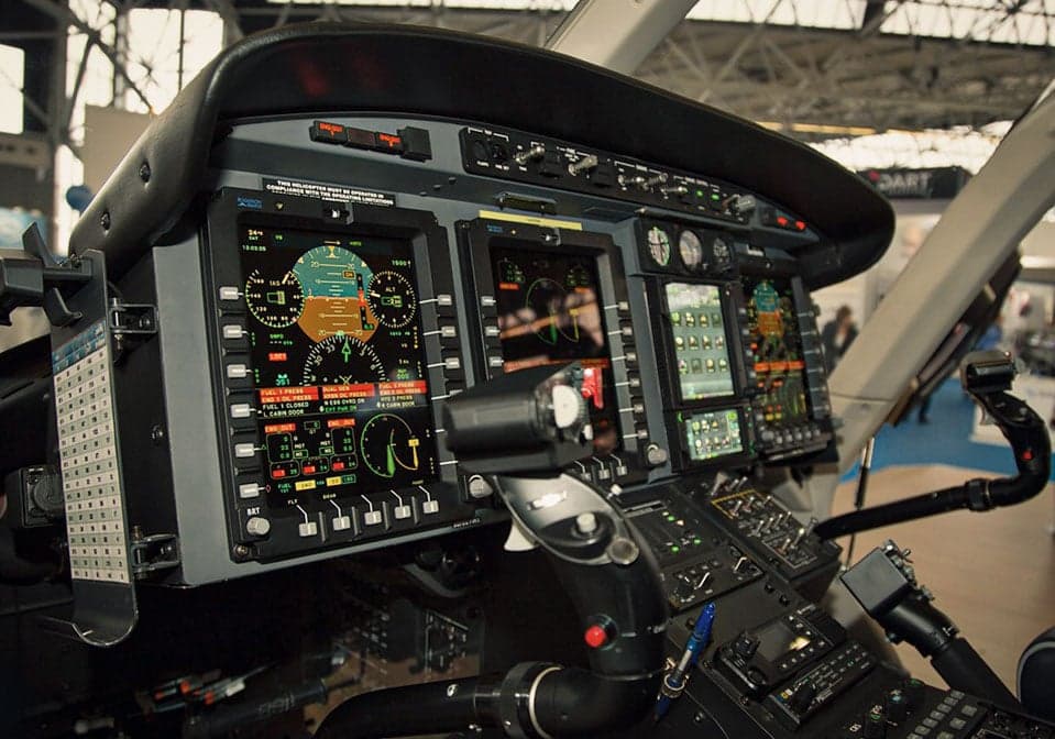 Close-up of the helicopter's instrument panel with multiple displays.