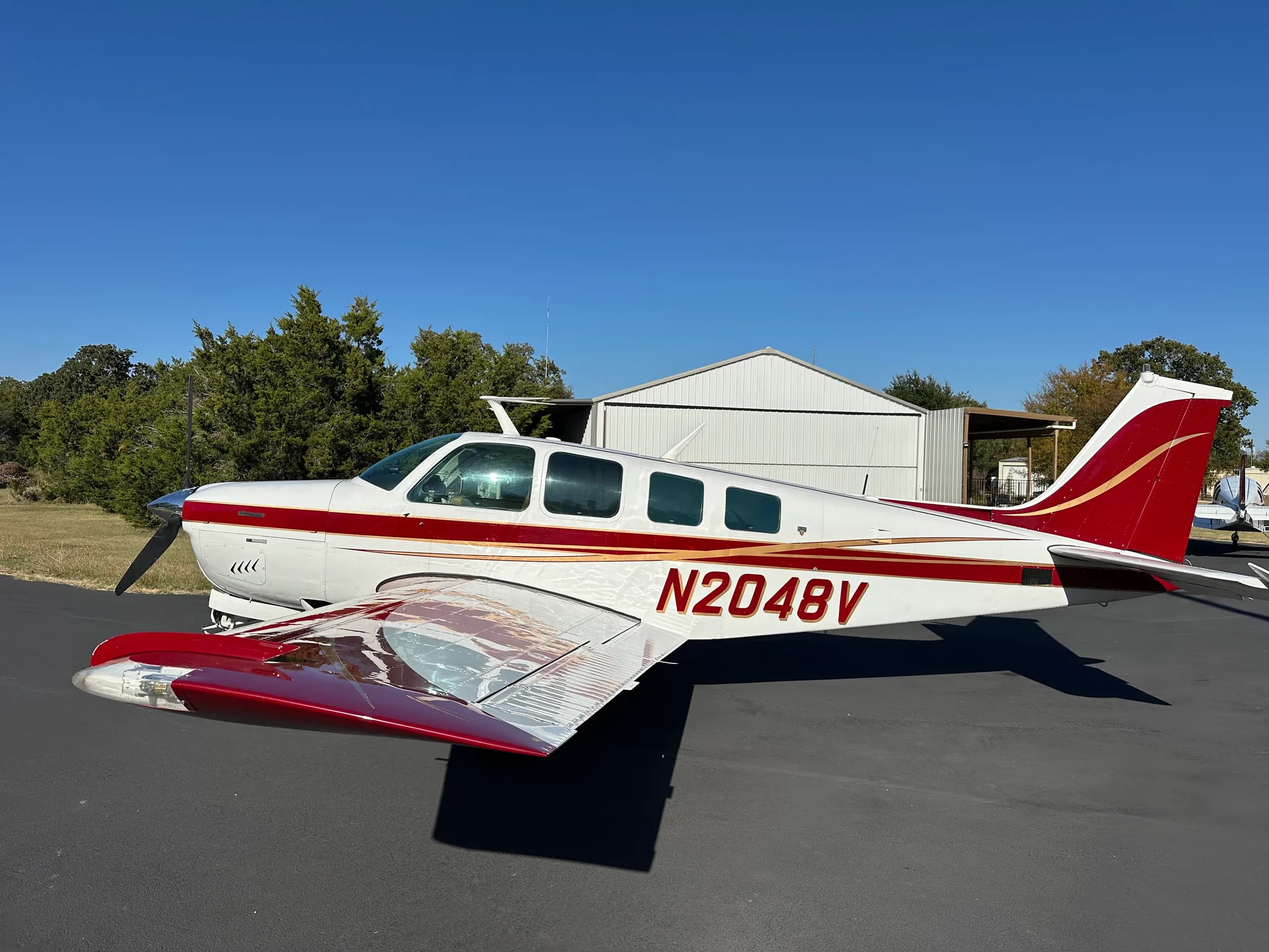 A Beechcraft Bonanza aircraft with registration N2048V is parked on the tarmac.